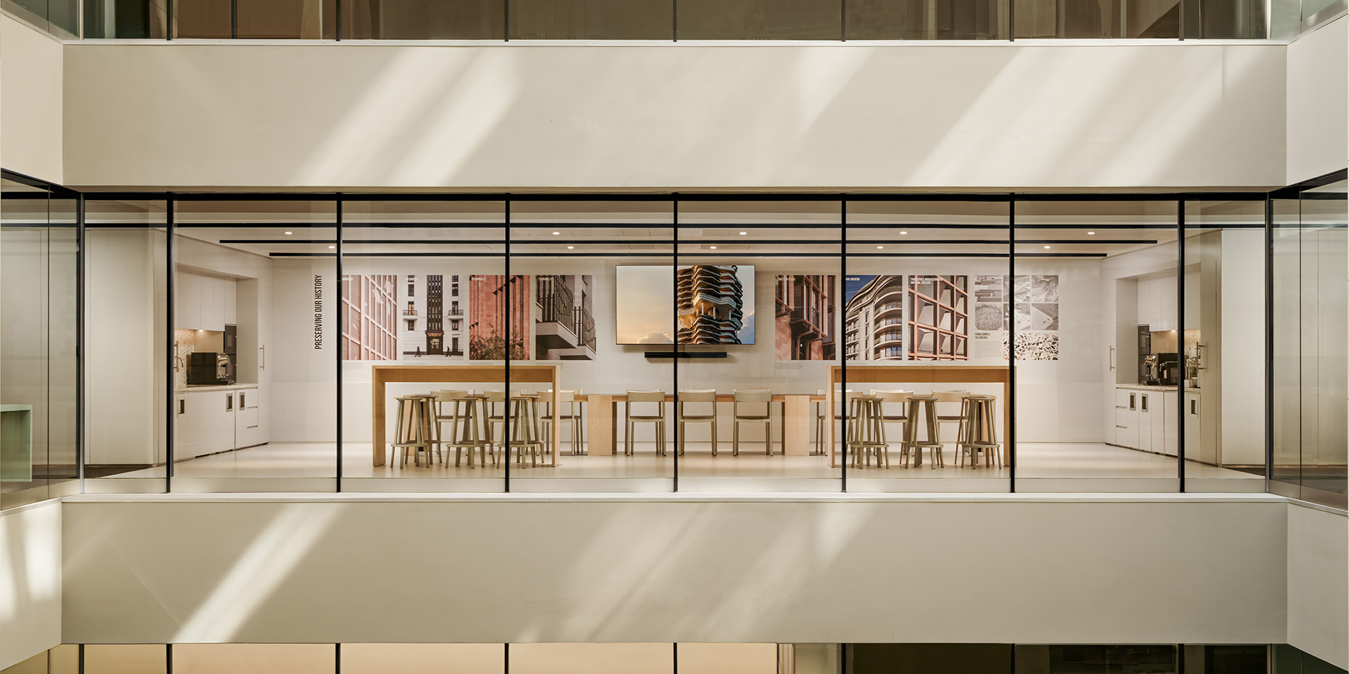 המשרד המחזורי של PLP Architecture מציג חלל עבודה נטרלי עם ריהוט עץ ותאורה טבעית